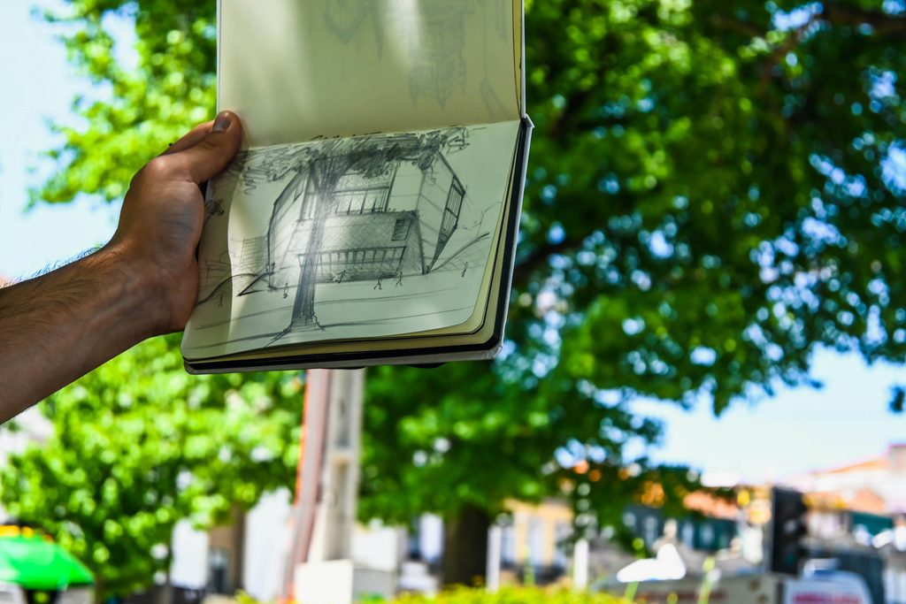 do flats need planning permission | Black Country Glazing Person holds open sketchbook showing architectural pencil drawing of a building, outdoors with green trees in the background